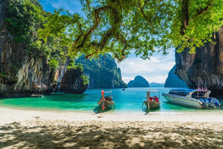 Longtail boats moored off a limestone island in Krabi